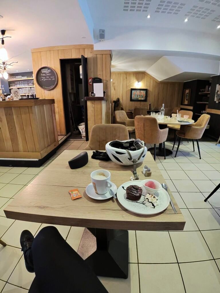 Coffee cup and a slice of cake on a café table in Souillac
