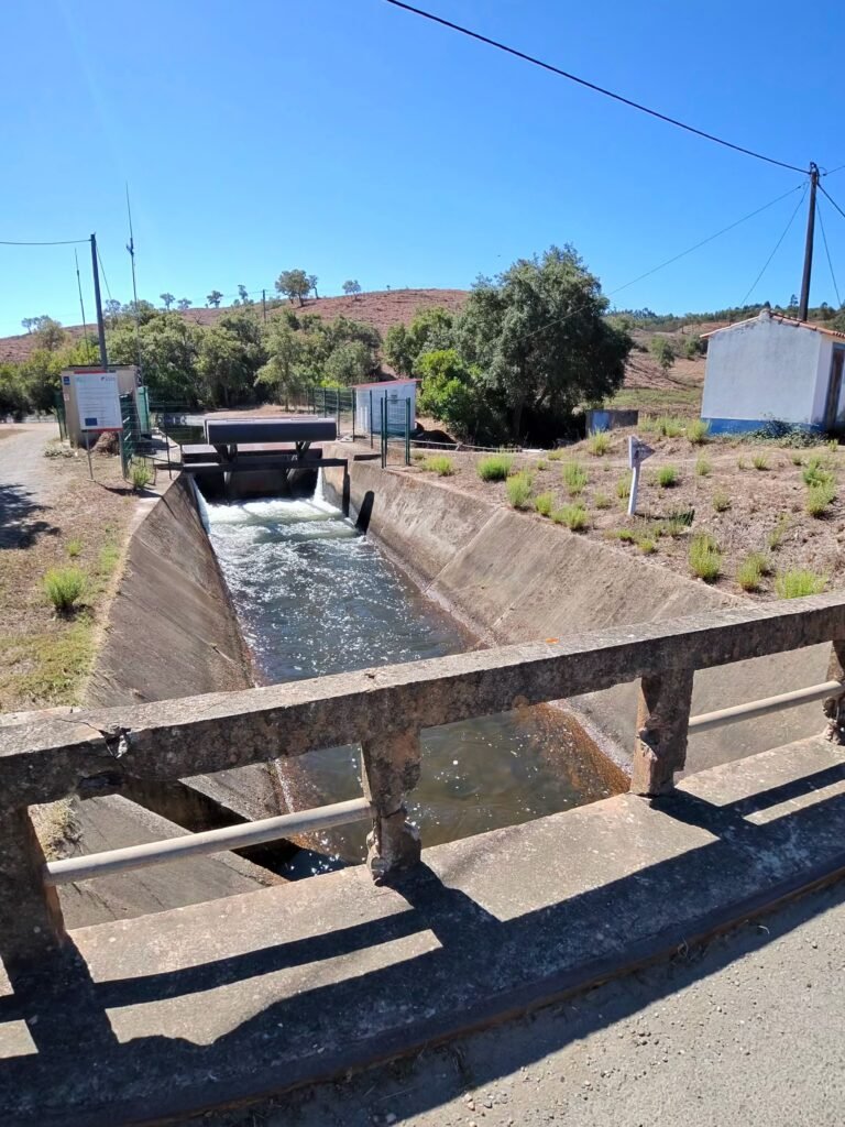 Concrete irrigation channel and sluice beside a farm road near Barranco do Inferno