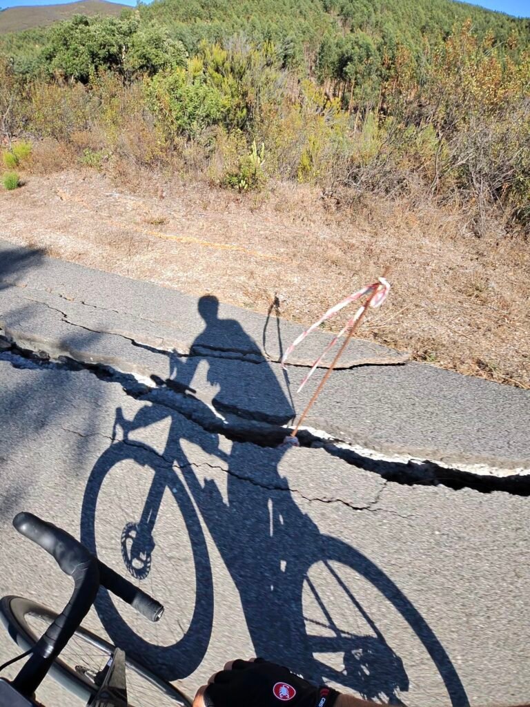 Rider and bike shadow on a cracked country road on the way back north